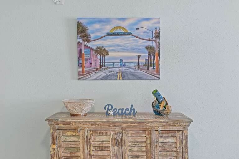 A rustic cabinet adds charm to the room, topped with beach-themed art and decor.