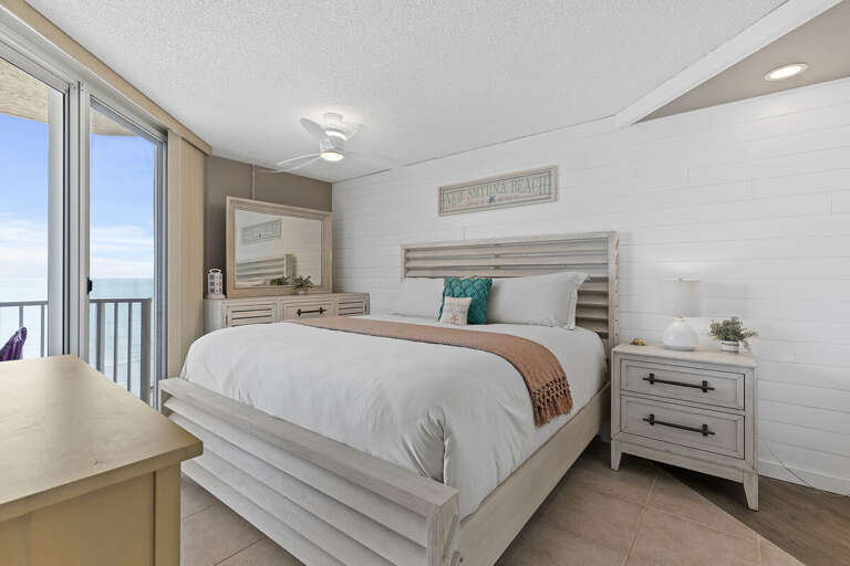 Spacious bedroom with ocean views, inviting bedding, and charming coastal accents.