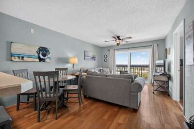 Relax in this inviting coastal living and dining area featuring comfortable seating, warm wood
