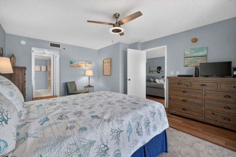 Settle into this spacious coastal bedroom featuring beach-inspired décor, a TV, ample storage,