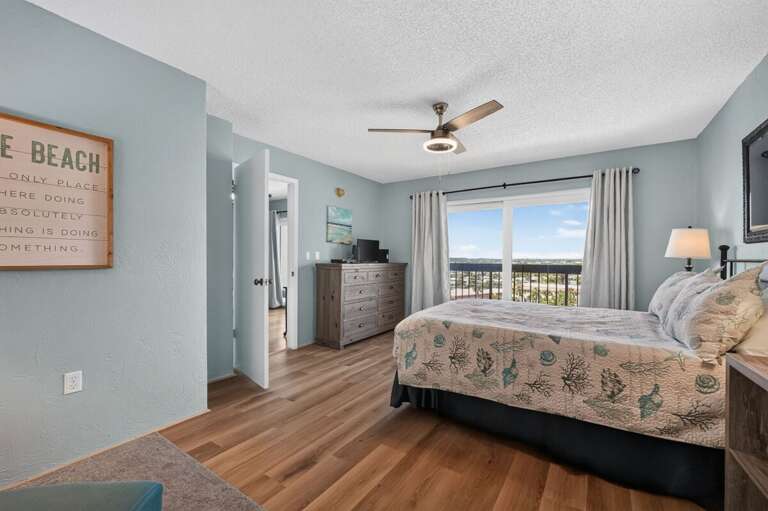 Wake up to bright coastal views from this inviting bedroom featuring beach-inspired décor, comfortable furnishings, and direct balcony access—a relaxing retreat for enjoying your beach stay.