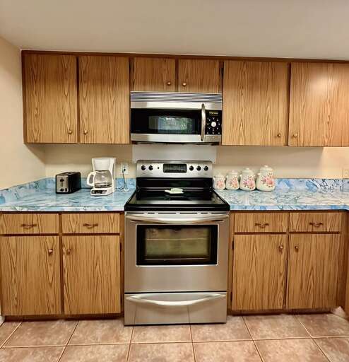 This well-stocked kitchen features a stainless steel oven, microwave, drip-style coffee maker, and toaster.
