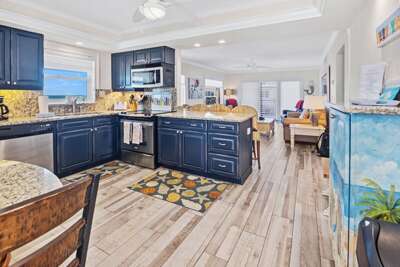 Enjoy cooking in this stylish beach condo kitchen featuring granite counters, modern appliances, and an open layout that flows into the living area—perfect for relaxing after a day by the ocean.