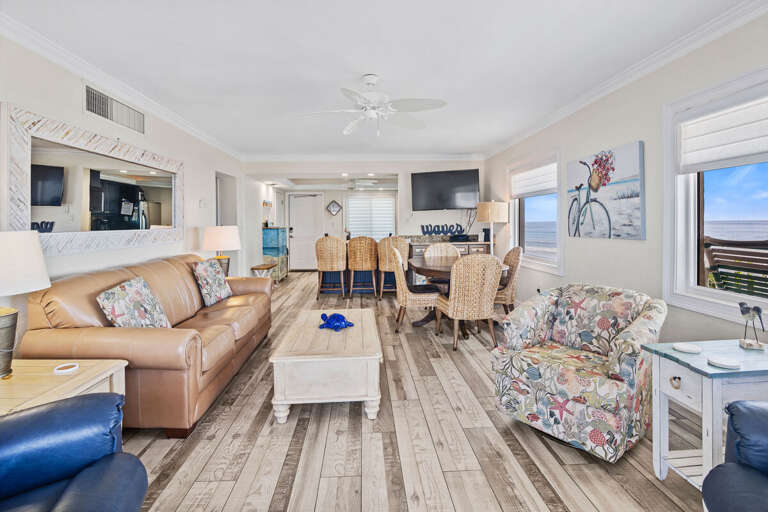 Enjoy open-concept living with coastal décor, ample seating, and ocean views. Perfect for relaxing or entertaining after a day at the beach, with dining space for family and friends.