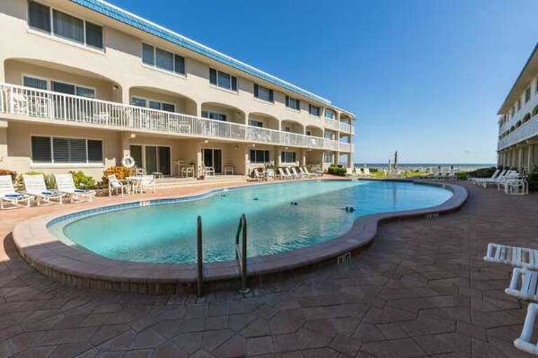 Relax at this inviting pool just steps from the beach. Perfect for your coastal getaway, offering lounge seating, sunny skies, and easy access to the sand and surf.