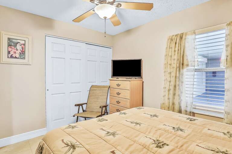 Vacation Rental: Bright Bedroom With Palm-patterned Bedding And Ceiling Fan