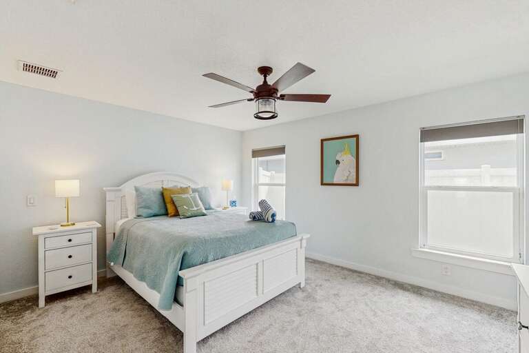 Bright and airy beach-style primary bedroom featuring plush bedding, soft coastal décor, and relaxing natural light—an ideal escape after sun-soaked seaside adventures.