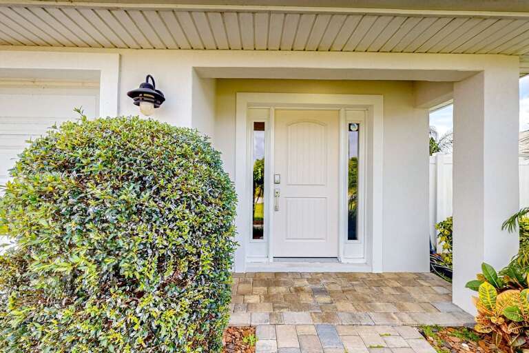 Bright, inviting front entry with coastal charm and clean landscaping—setting the perfect tone for a relaxing beach getaway the moment you arrive.