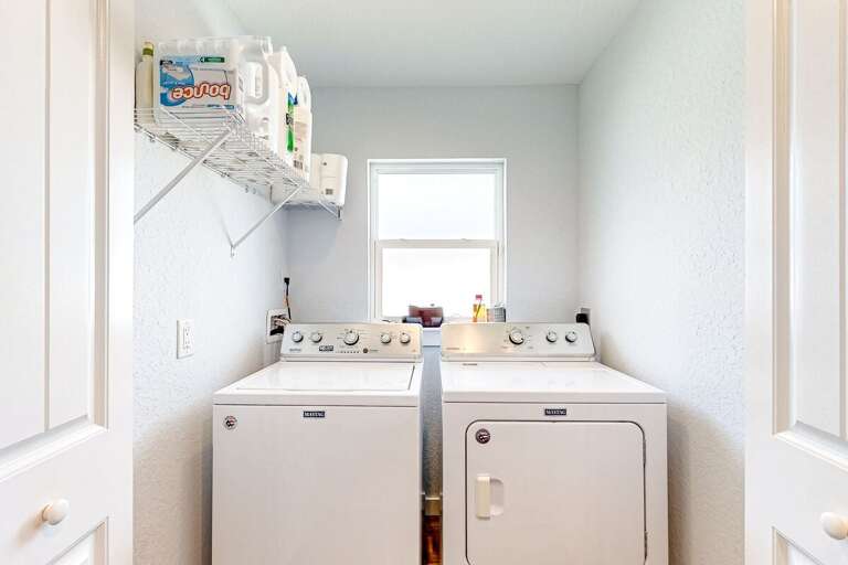 Bright laundry room with full-size washer and dryer—perfect for refreshing beach towels, swimsuits, and sandy clothes during your coastal getaway.
