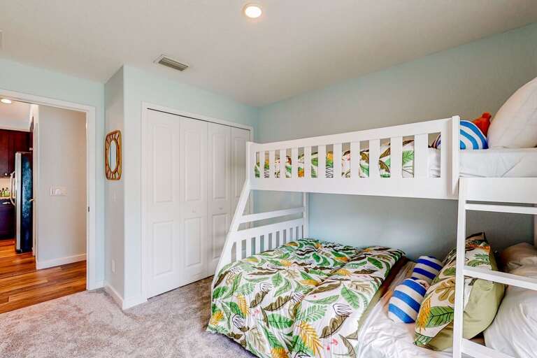 Colorful beach-inspired bunk room with cozy bedding and plenty of space—perfect for kids to relax and recharge after fun days in the sun and surf.