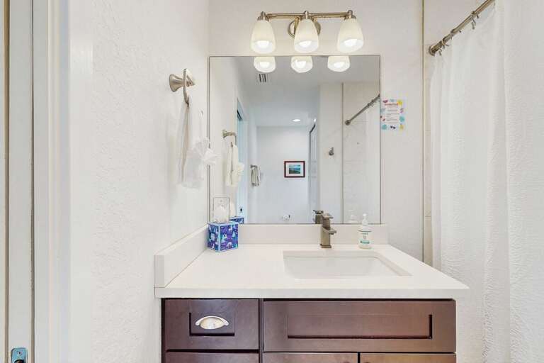 Fresh beach-inspired bathroom with a sleek vanity, bright lighting, and soft towels—perfect for getting ready for a day on the sand or unwinding after coastal adventures.