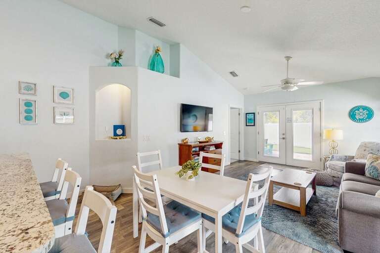 Gather in this airy beach-inspired dining and living space featuring coastal décor, comfy seating, and easy access to the patio—perfect for relaxing after a fun-filled beach day.