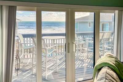 Seaside View From A Vacation Rental Showing A Balcony Overlooking Beach Waves