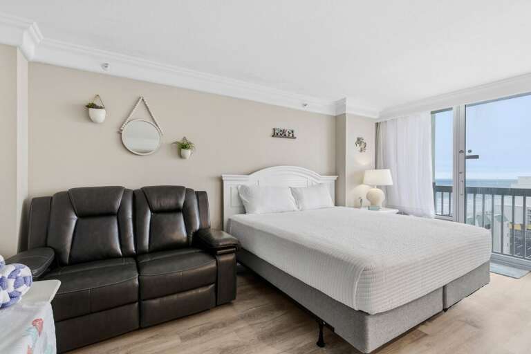 Bedroom With Bed, Black Chairs, Balcony Access