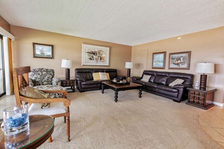 Enjoy this inviting coastal living room featuring plush leather seating, tasteful décor, and warm tones—perfect for unwinding after a sunny day at the beach during your beachfront stay.