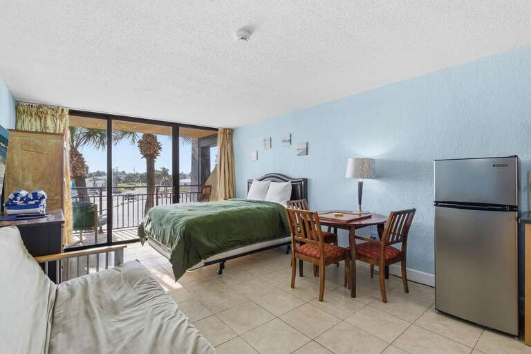 Bright beachfront studio featuring a plush queen bed, private balcony with palm views, and steps to