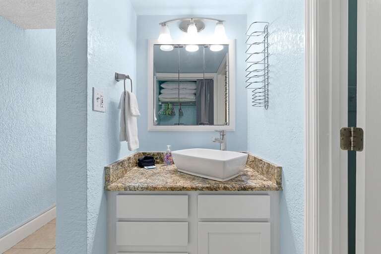 Fresh and bright bathroom featuring a modern vessel sink, granite vanity, and plush towels—ideal
