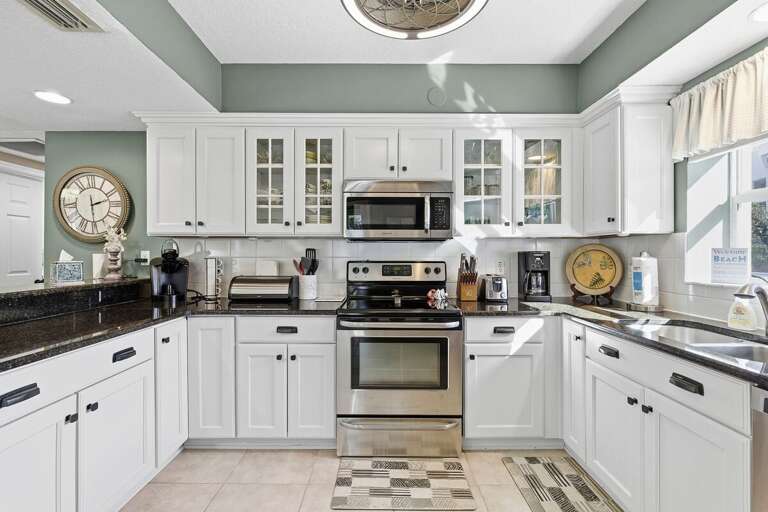 Fully equipped, sunlit kitchen with modern appliances, ample counter space, and coastal charm. Perfect for preparing meals during your beach stay, just steps from relaxation and ocean-inspired living.