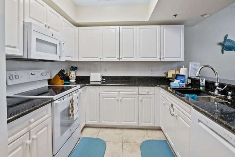 Prepare meals with ease during your beach stay in this fully equipped kitchen featuring modern