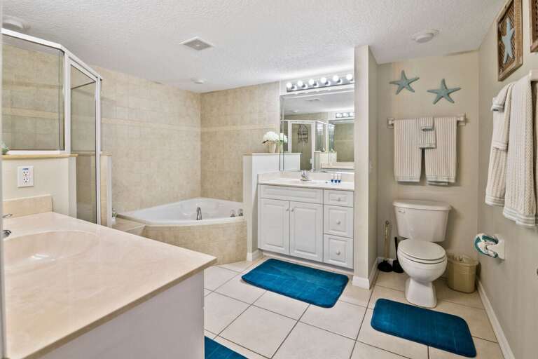 Refresh during your beach stay in this spacious coastal bathroom featuring a soaking tub, walk-in shower, and large vanity. The perfect place to unwind and recharge after a sunny day at the beach.