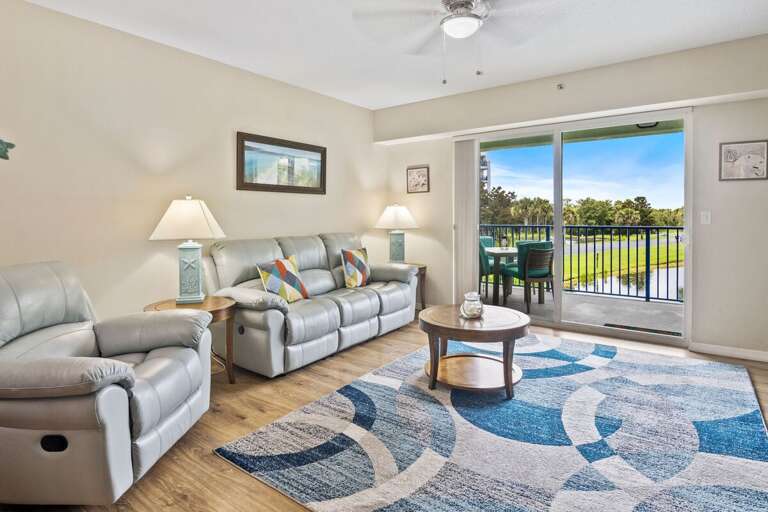 Relax during your beach stay in this bright coastal living room featuring plush seating and sliding