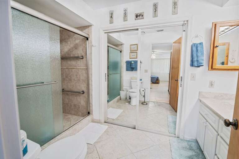 Bright ensuite bathroom with walk-in shower, grab bars, and ample vanity space. Designed for comfort