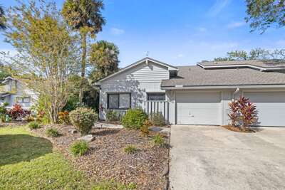 Bright and inviting beach stay featuring tropical landscaping, private garage, and a peaceful