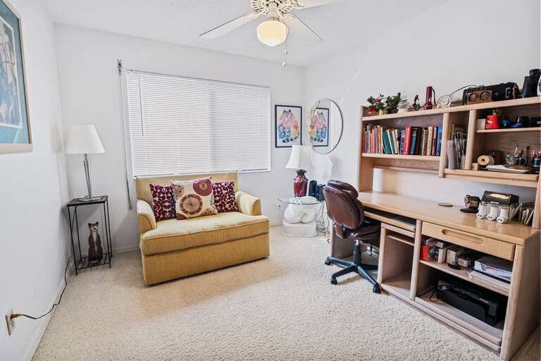 Bright, versatile space with desk, bookshelves, and comfy seating—ideal for remote work or quiet