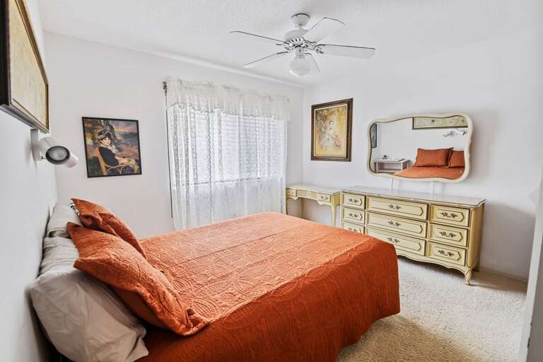 Charming guest bedroom with plush bedding, classic furnishings, and soft natural light. This inviting beach stay retreat offers a peaceful place to unwind after a fun-filled day by the ocean.