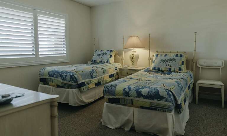 This cozy twin bedroom in your beach stay features two comfortable beds, coastal-themed bedding, and