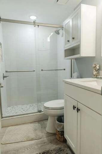 Fresh and modern bathroom in this relaxing beach stay featuring a glass walk-in shower, updated