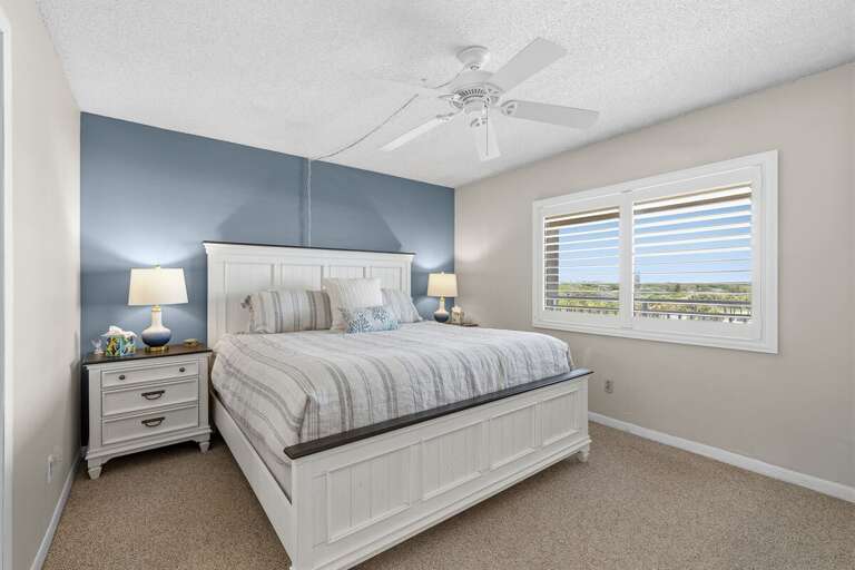 Rest comfortably in this serene coastal bedroom featuring soft décor, natural light, and peaceful