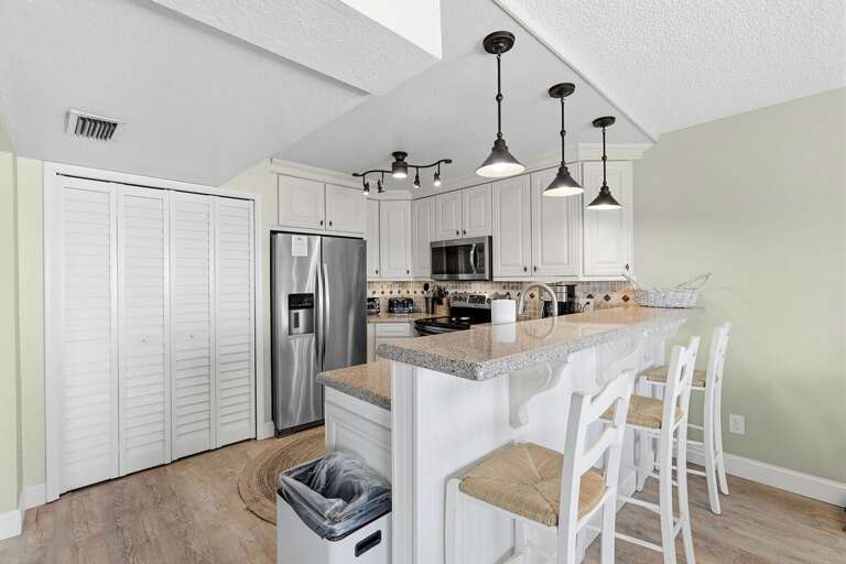 Start your day in this bright coastal kitchen featuring stainless steel appliances, bar seating, and