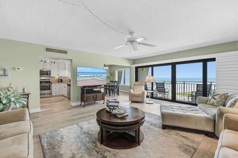 Unwind in this bright oceanfront condo featuring panoramic beach views, an open living area, and