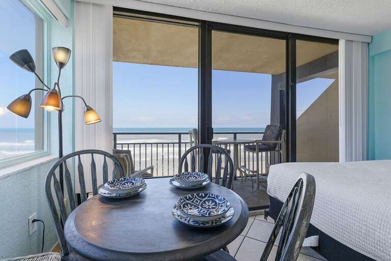 Dine with stunning ocean views in this beach stay, featuring a cozy dining nook and direct balcony