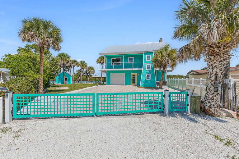 Welcome to your beach stay getaway at this vibrant coastal home featuring a spacious yard,