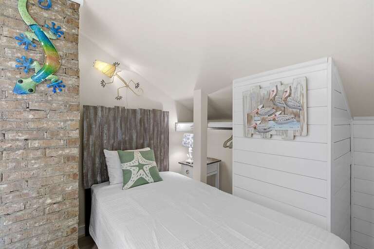 Charming twin bedroom with beach-inspired décor, nautical accents, and cozy comfort. Ideal for a relaxing beach stay, this inviting space offers a peaceful retreat after sun-filled days by the shore.