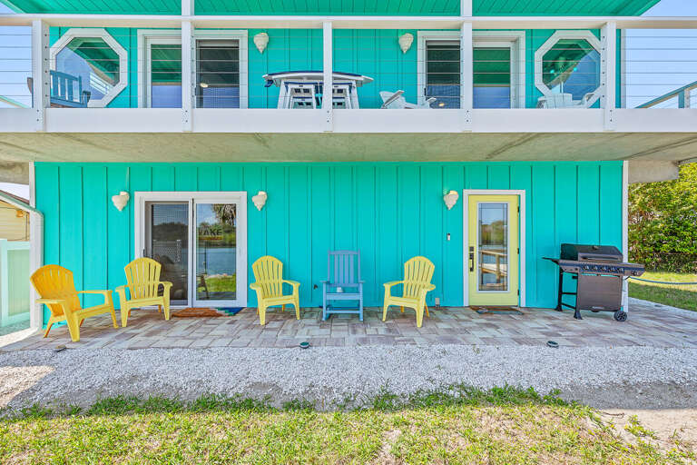 Enjoy your beach stay on this inviting outdoor patio featuring colorful seating and a grill for easy cookouts. Perfect for relaxing, dining, and soaking up the laid-back coastal lifestyle.