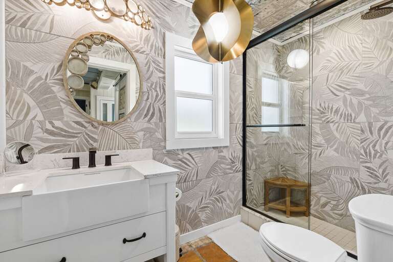Enjoy a stylish beach stay in this beautifully updated bathroom featuring coastal-inspired tile, a