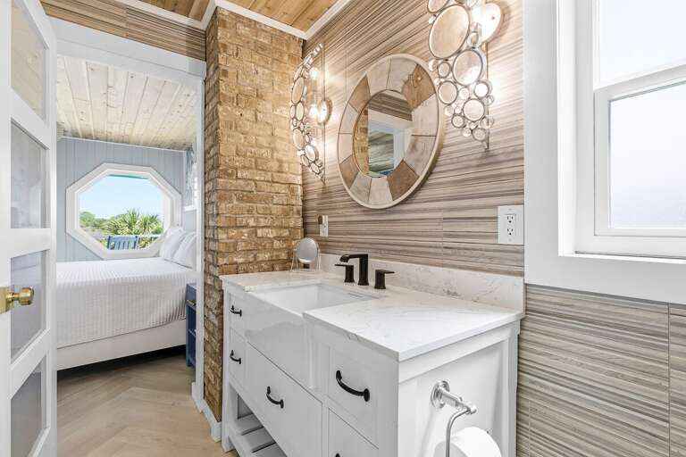 Refresh in this coastal-inspired bathroom featuring a sleek vanity, modern fixtures, and unique