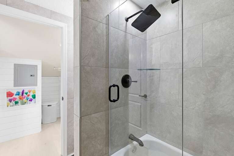 Refresh in this modern coastal shower with glass enclosure, stylish tile, and matte black fixtures.