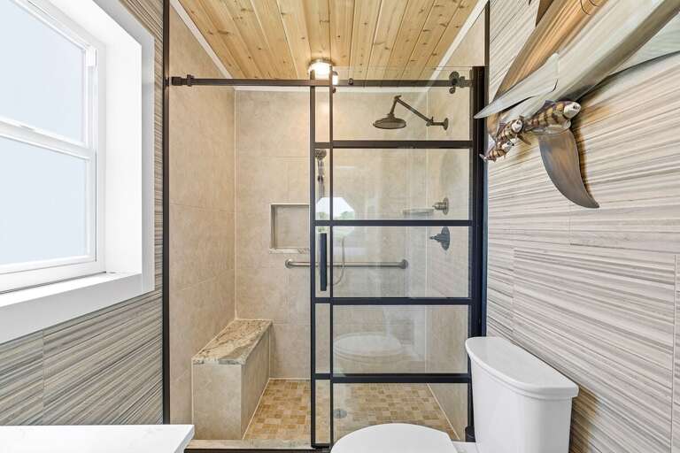 Refresh in this stylish walk-in shower featuring sleek glass doors, tile finishes, and coastal accents. Perfect for a beach stay, enjoy a spa-like space to unwind and recharge after a day in the sun.