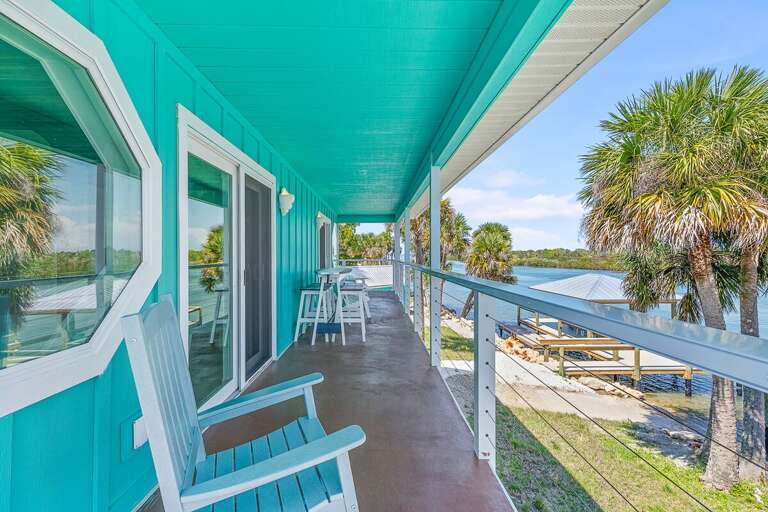 Relax during your beach stay on this spacious waterfront balcony with Adirondack seating and a
