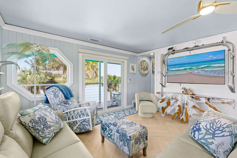 Relax in this bright coastal living space featuring beach-inspired décor, plush seating, and