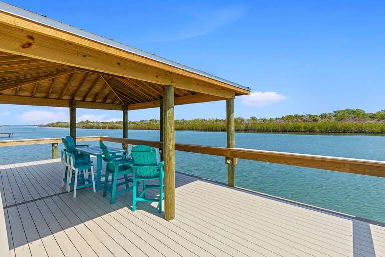 Savor your beach stay from this covered waterfront dock with outdoor seating and stunning views. Perfect for dining, relaxing, and enjoying peaceful coastal breezes right over the water.