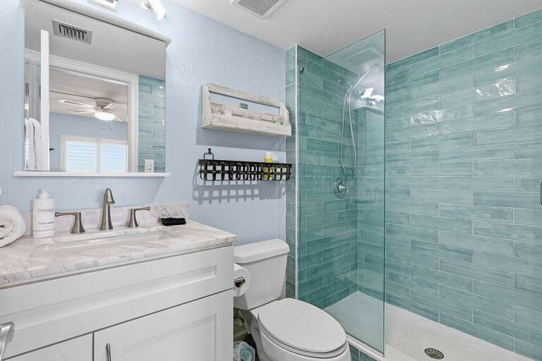 Refresh during your beach stay in this coastal bathroom featuring a sleek walk-in shower, modern finishes, and bright, beach-inspired design—perfect after a day in the sun and surf.