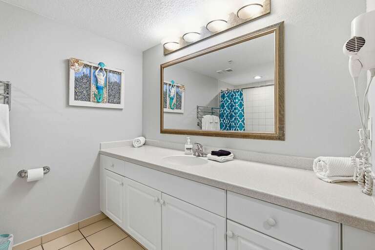 Spacious beach stay bathroom featuring a large vanity, ample counter space, and coastal touches. Enjoy a clean, comfortable space to get ready before heading out for a day at the beach.