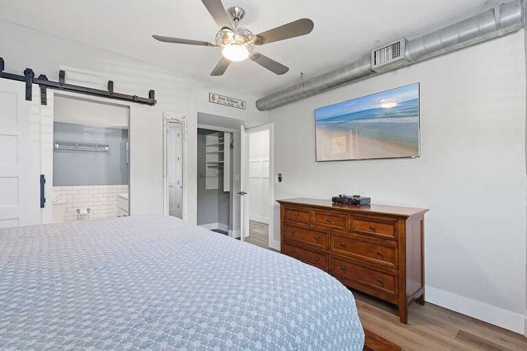 Enjoy a relaxing beach stay in this spacious bedroom featuring comfortable bedding, coastal décor,