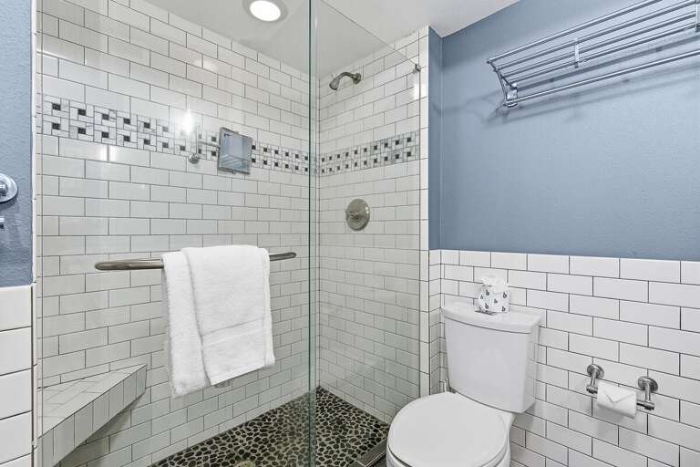 Refresh after your beach stay in this sleek bathroom featuring a walk-in tiled shower, glass enclosure, and coastal-inspired design. A clean, relaxing space perfect for rinsing off after the beach.
