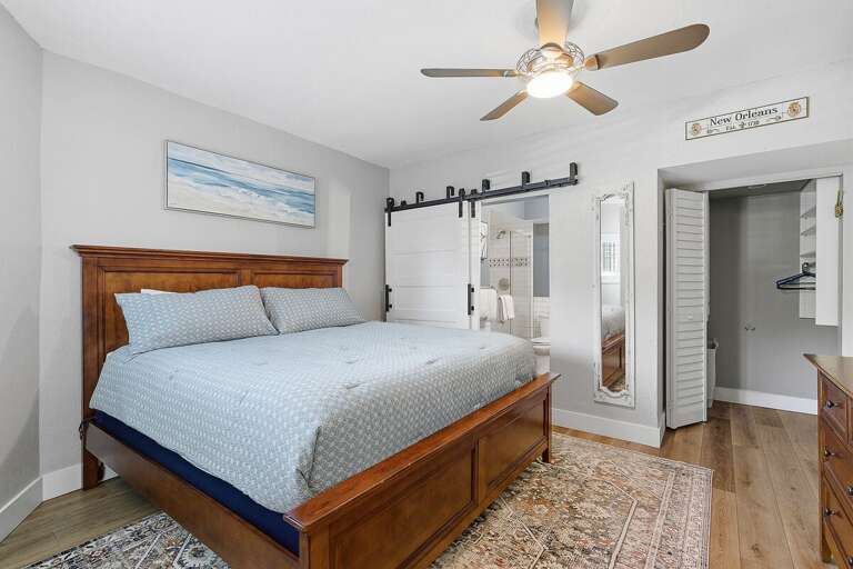 Relax in this inviting beach stay bedroom featuring a comfortable bed, coastal décor, and sliding